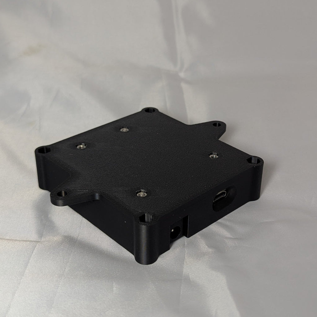 The bottom of a black electronic enclosure on a white background