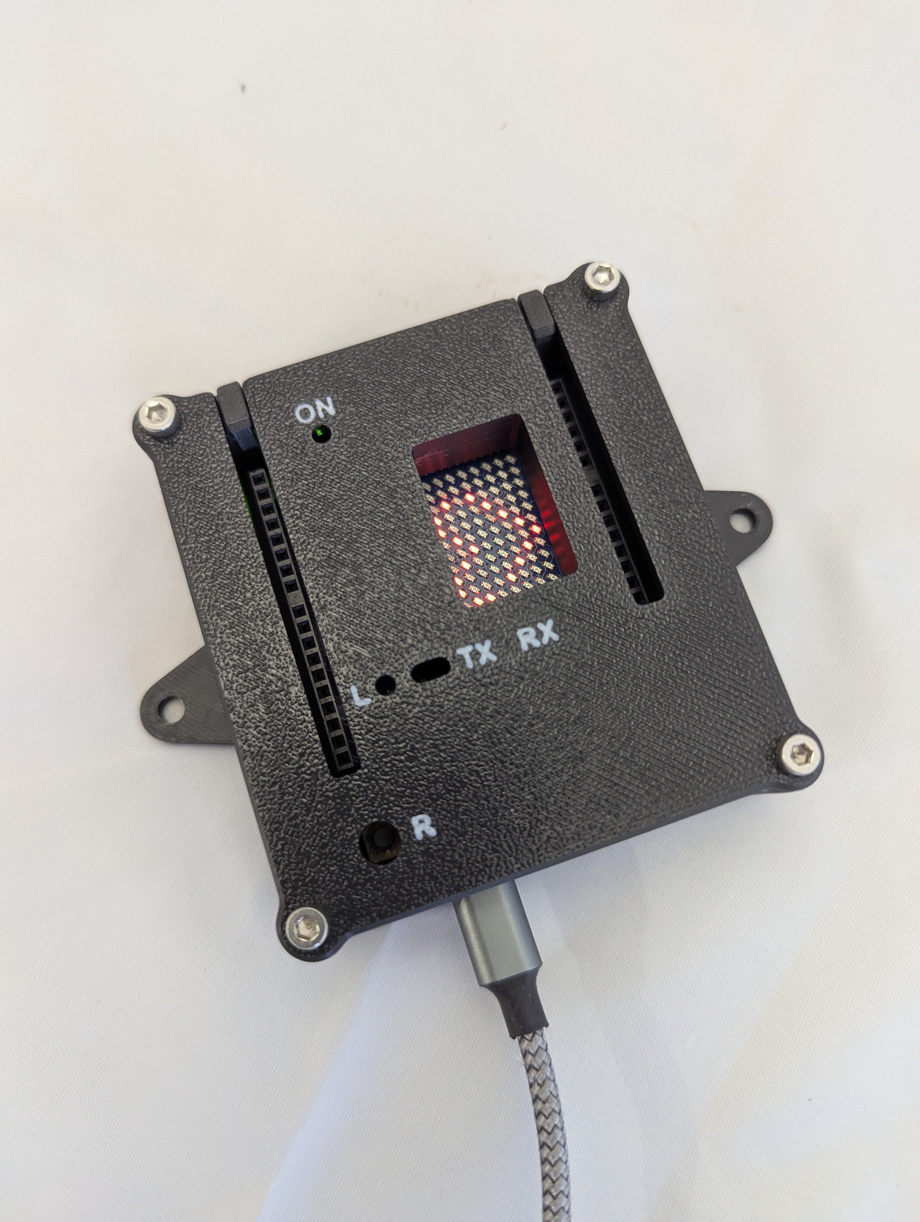 Electronic enclosure with cutout showing a small LED matrix on a white background