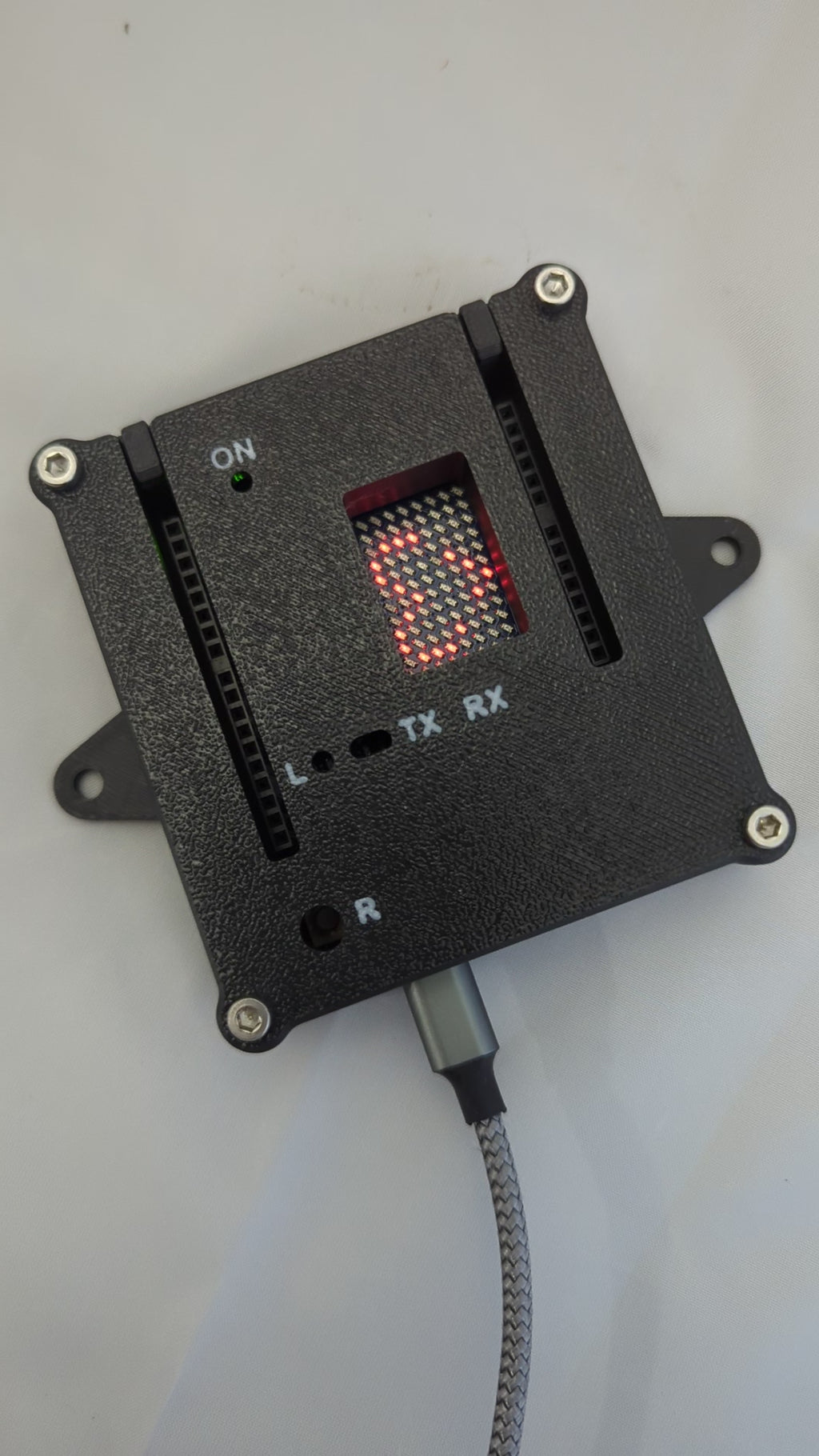 Video showing a heart and smiley graphic on an LED Matrix of an Arduino in an black enclosure with white labels for the status LED ports.