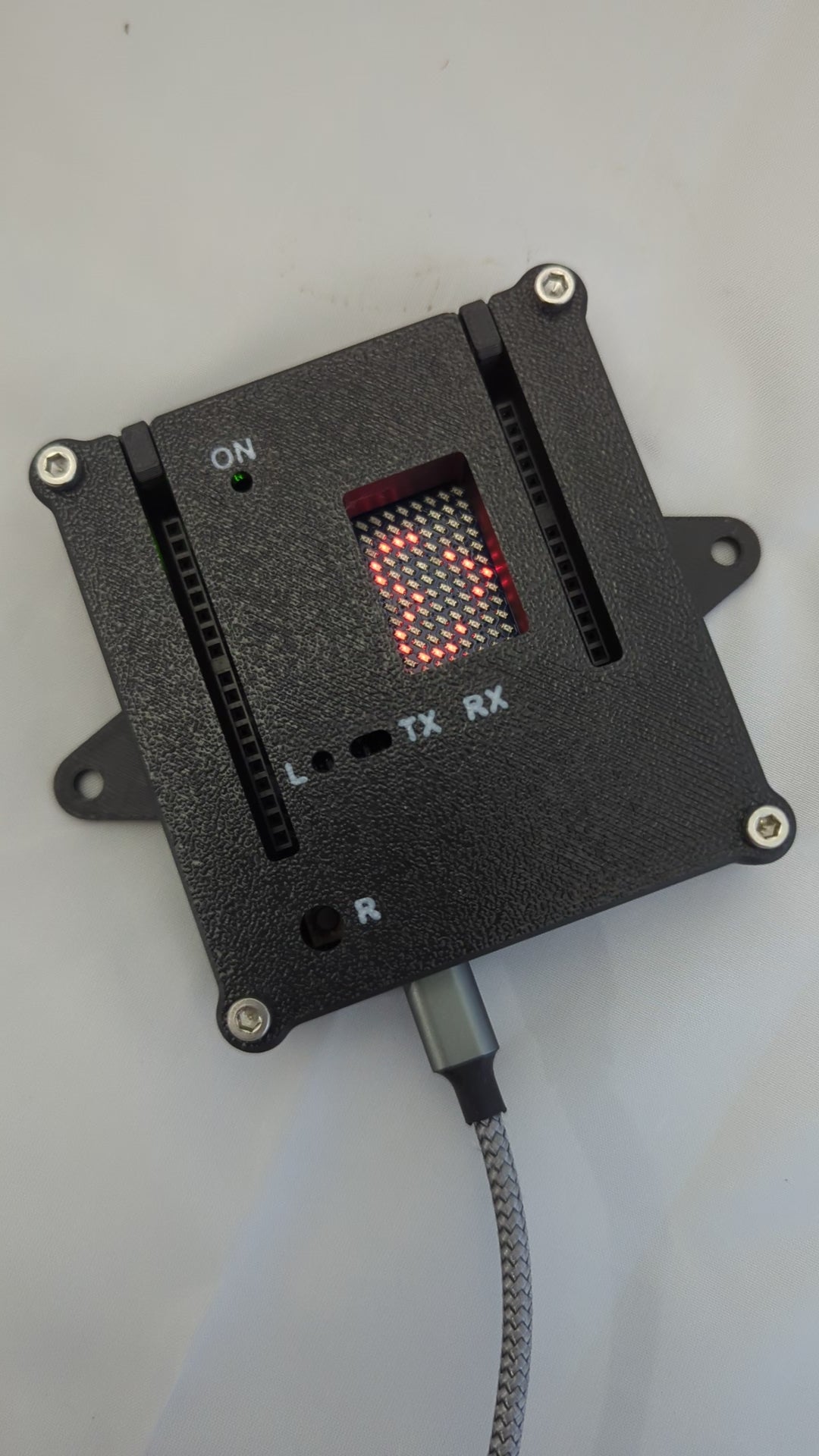 Video showing a heart and smiley graphic on an LED Matrix of an Arduino in an black enclosure with white labels for the status LED ports.